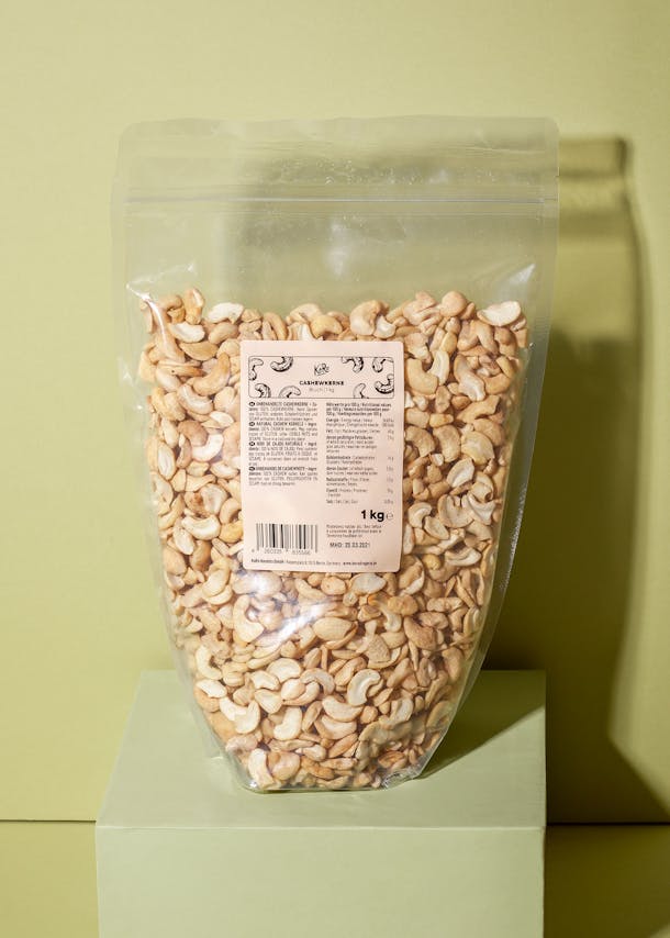 Beutel mit Cashewbruch auf grünem Podest