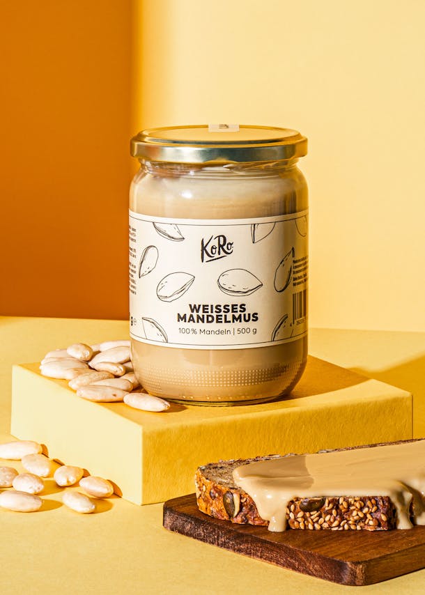 Glas mit weißem Mandelmus neben Brot