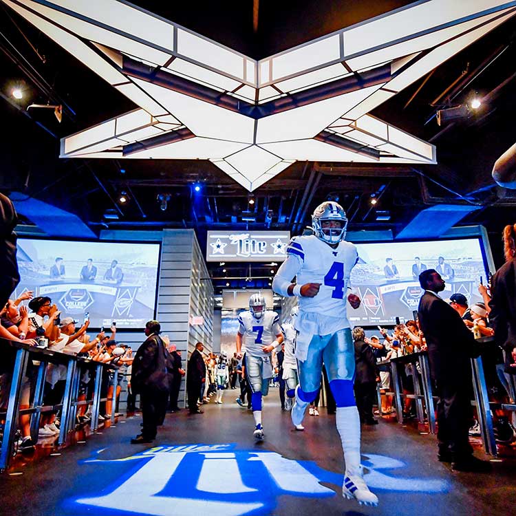 Dallas Cowboys players entering a stadium tunnel