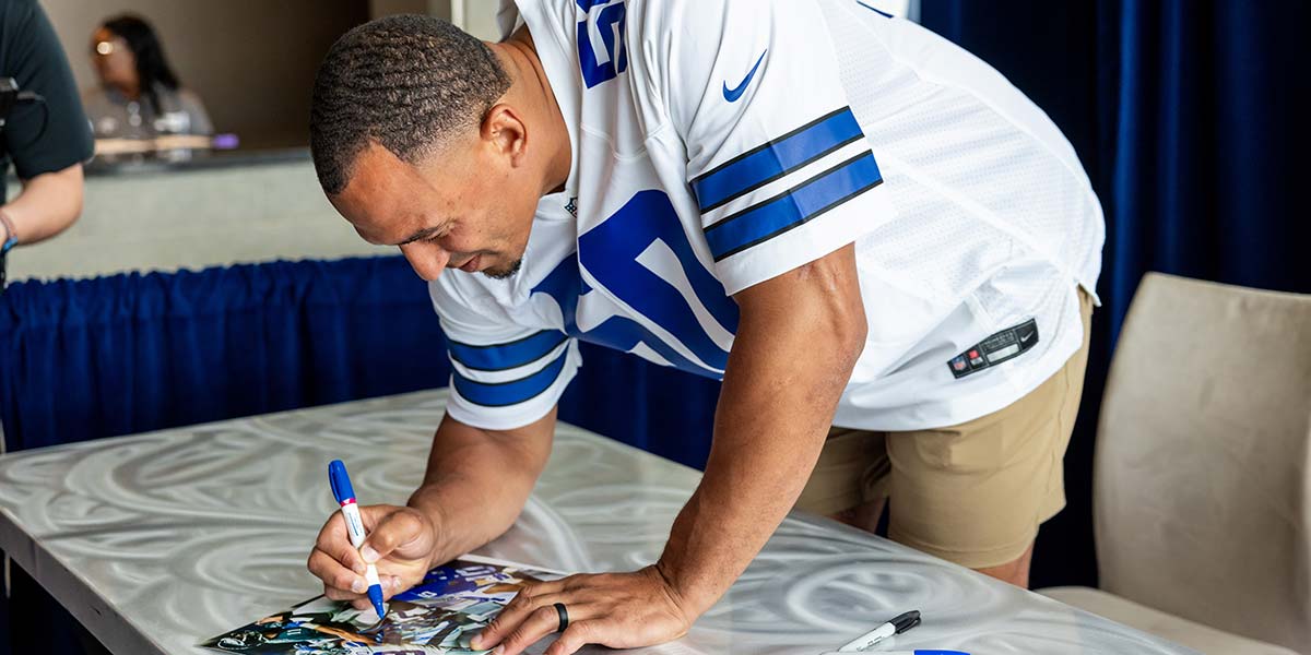 A fan signing an item during a stadium event