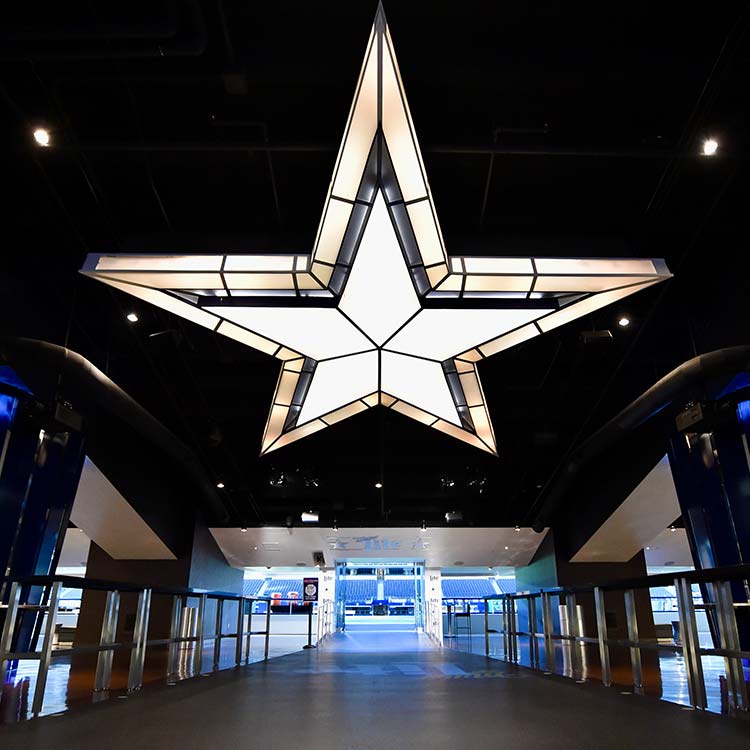 Illuminated star feature in an AT&T Stadium concourse