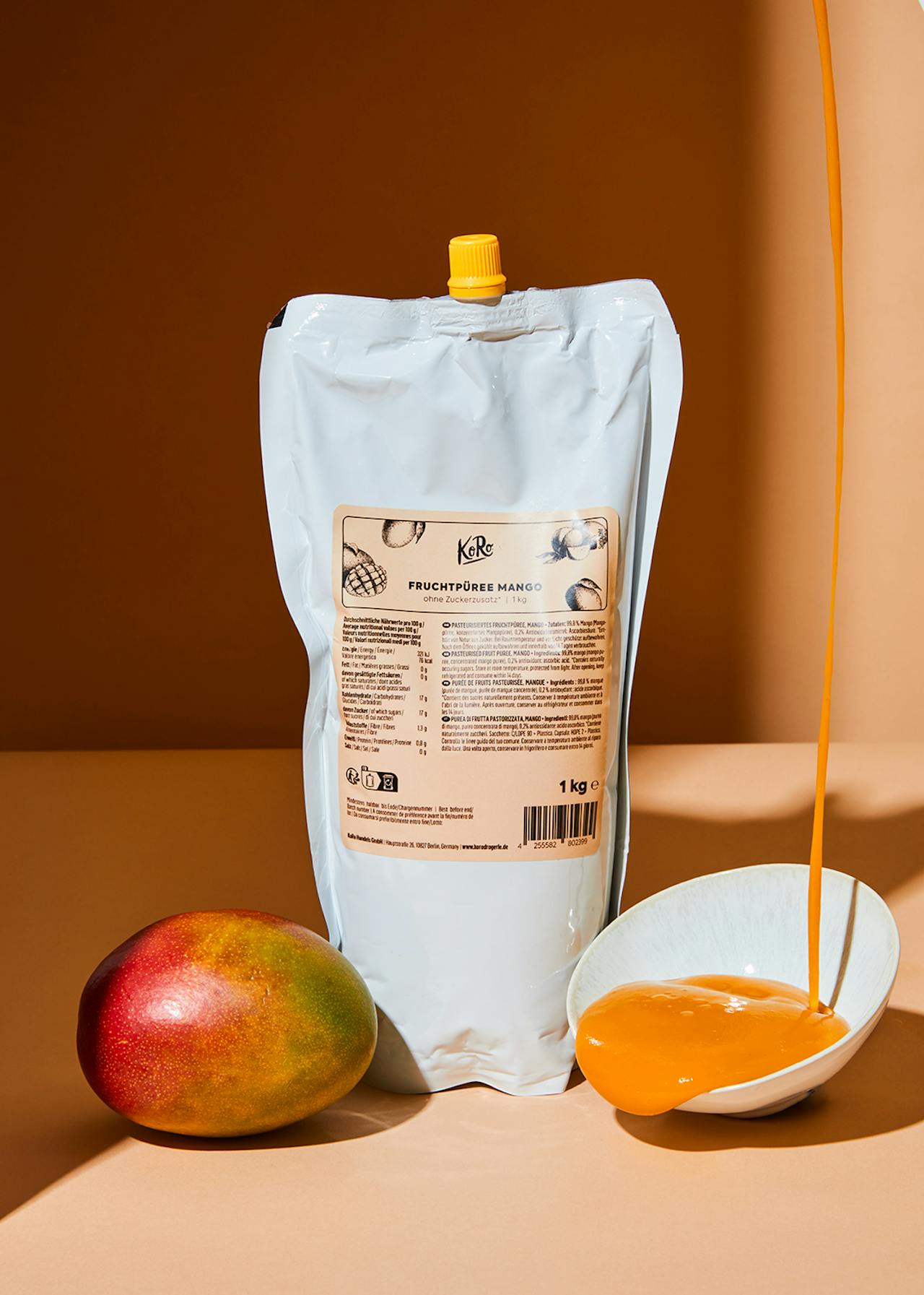 Beutel mit Mango-Fruchtpüree neben einer Mango