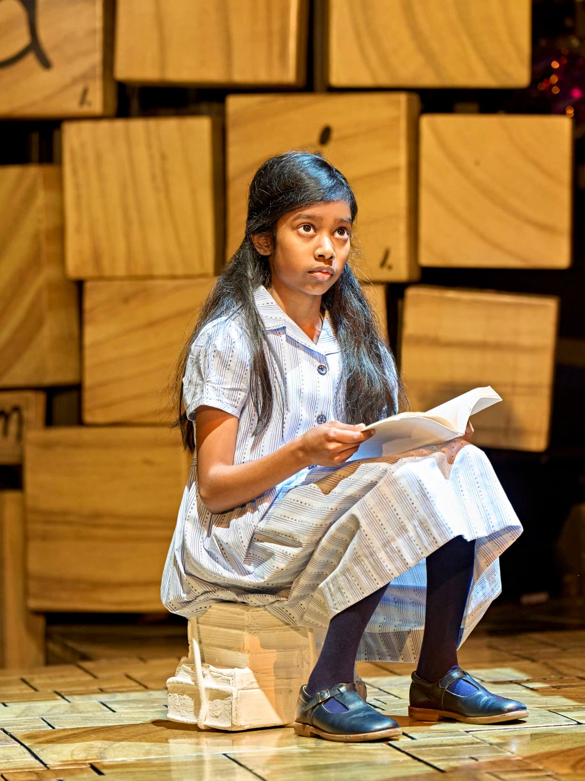 Sithuni Gamage as Matilda reading on stage
