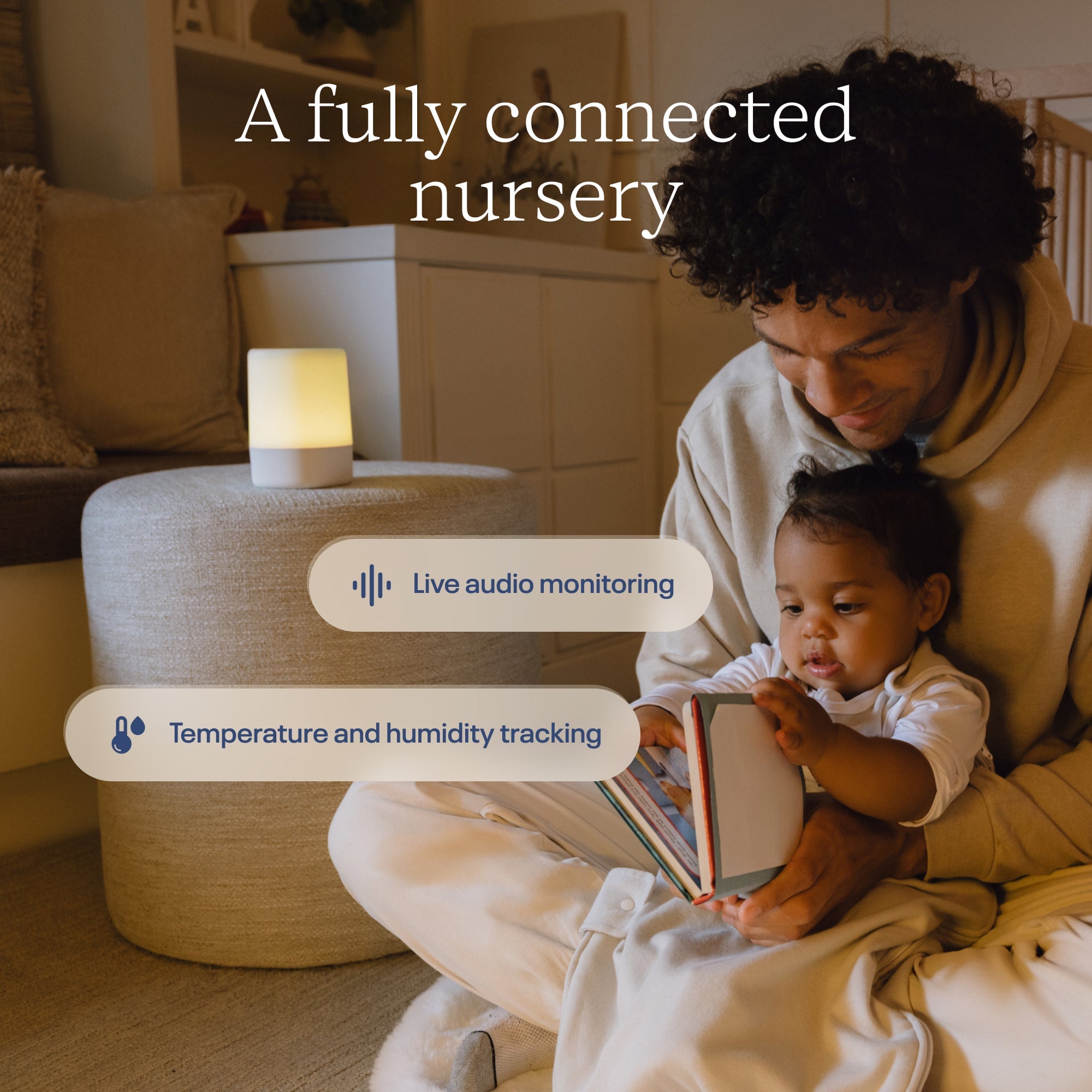 Parent holding a baby beside a Nanit Sound + Light Machine