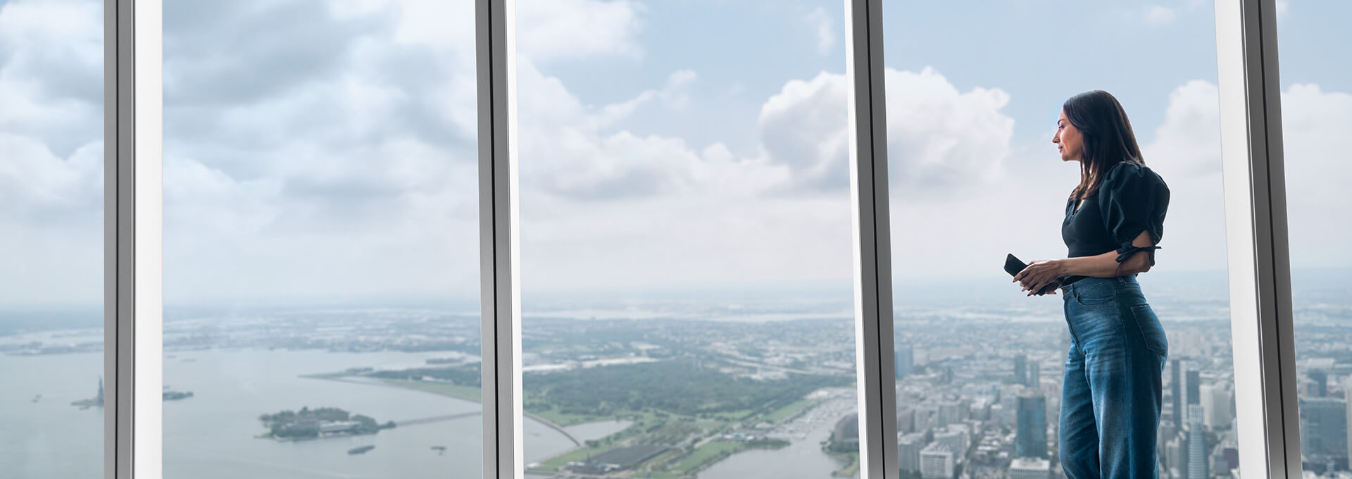 Woman viewing the daytime New York skyline from One World Observatory