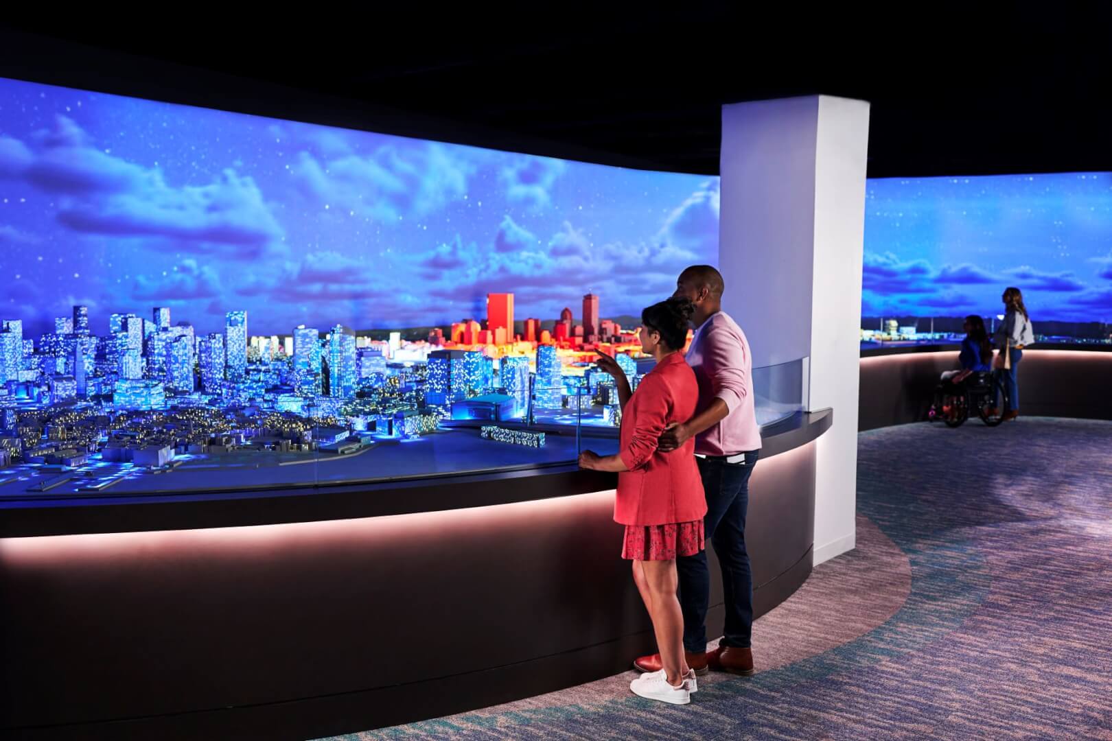 Visitors viewing an illuminated city model at View Boston