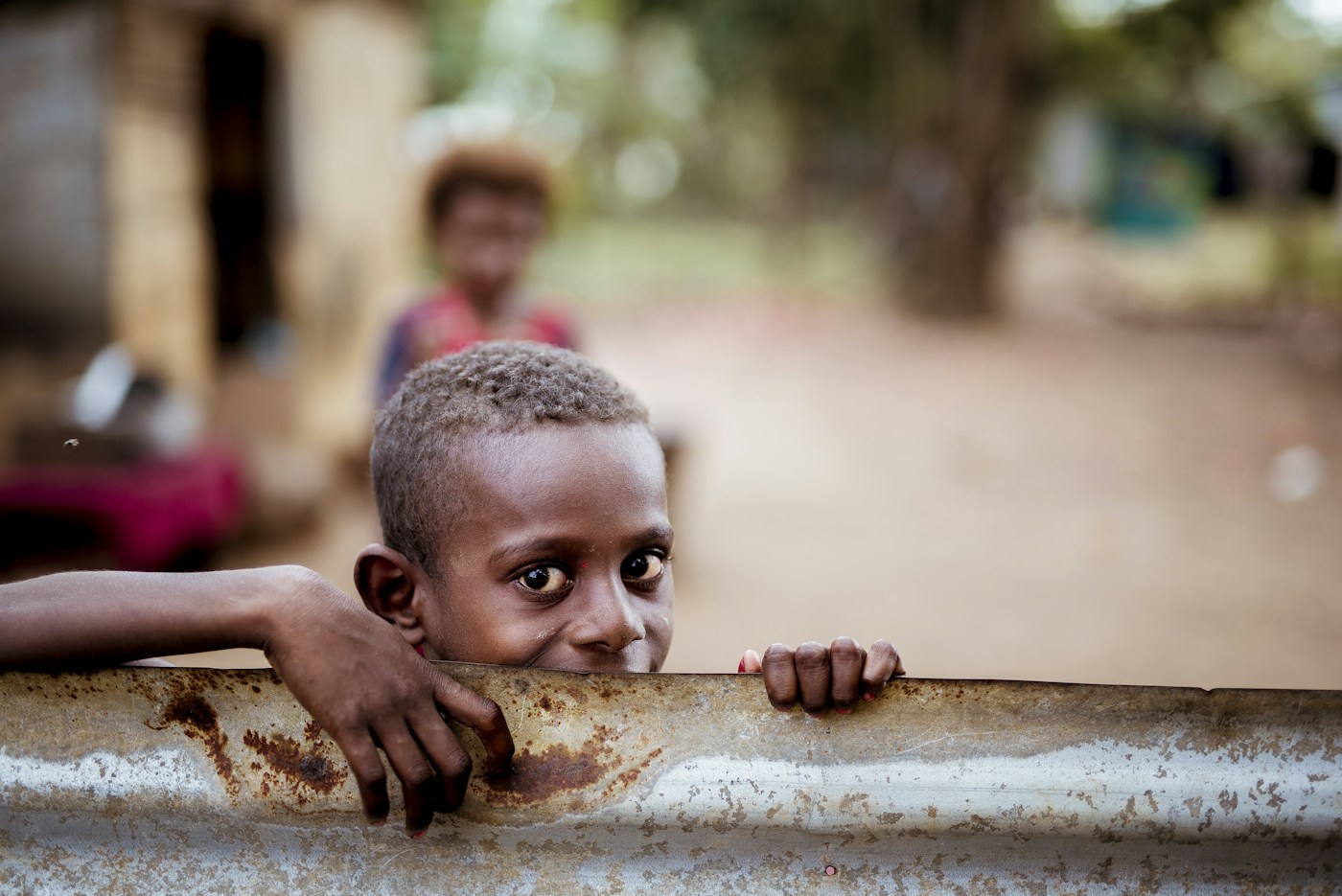 Child peeking over a fence
