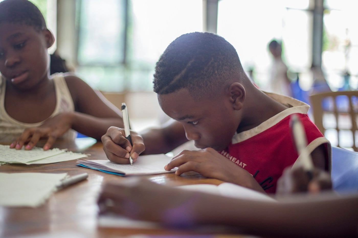 Children writing at a table