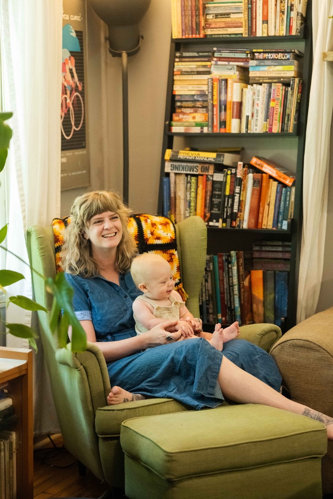 Mother holding a baby in a green armchair